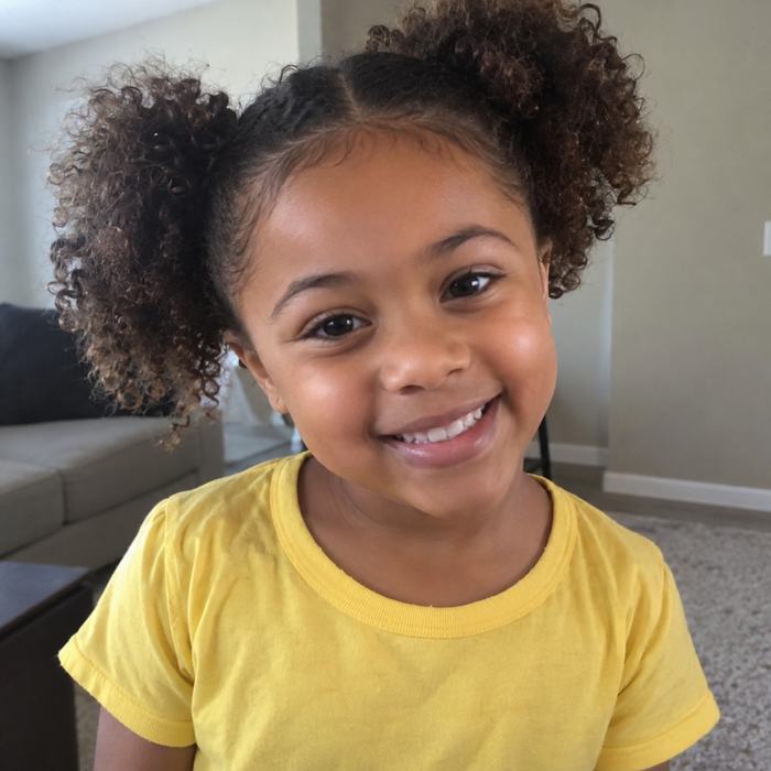 Photo of a smiling girl in a yellow shirt